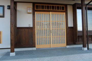 桧の引違い格子戸です。御影石のレール石、沓石としています。