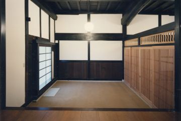 玄関のたたきの土間、片引き大戸と内側にはガラスの格子戸